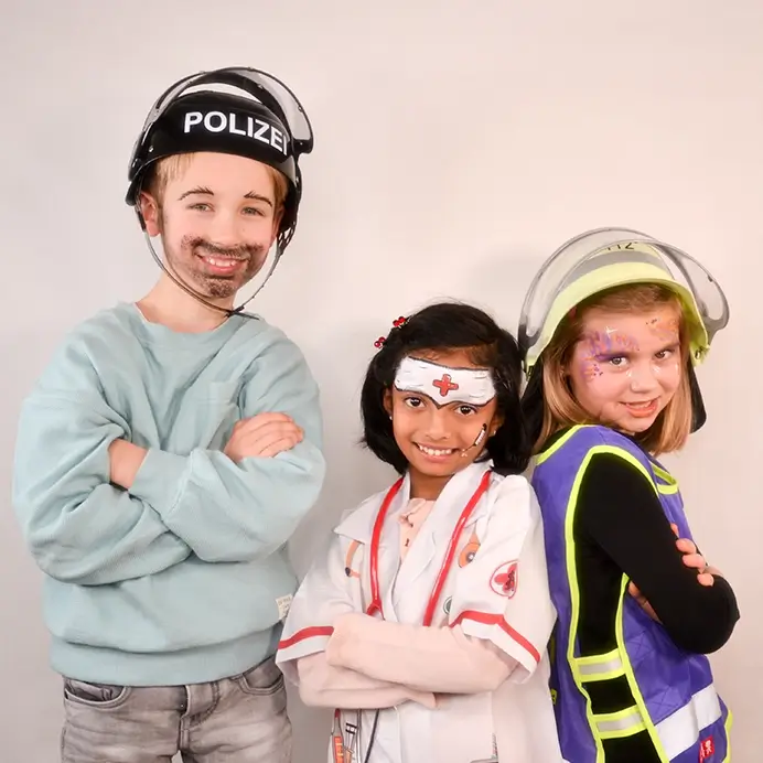 Kita-Projekt zum Thema Berufe, verkleidete Kinder als Polizei, Krankenschwester und Feuerwehr