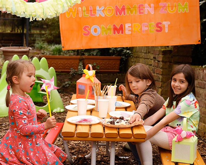Das Sommerfest im Kindergarten Kinder sitzen am Tisch beim Sommerfest