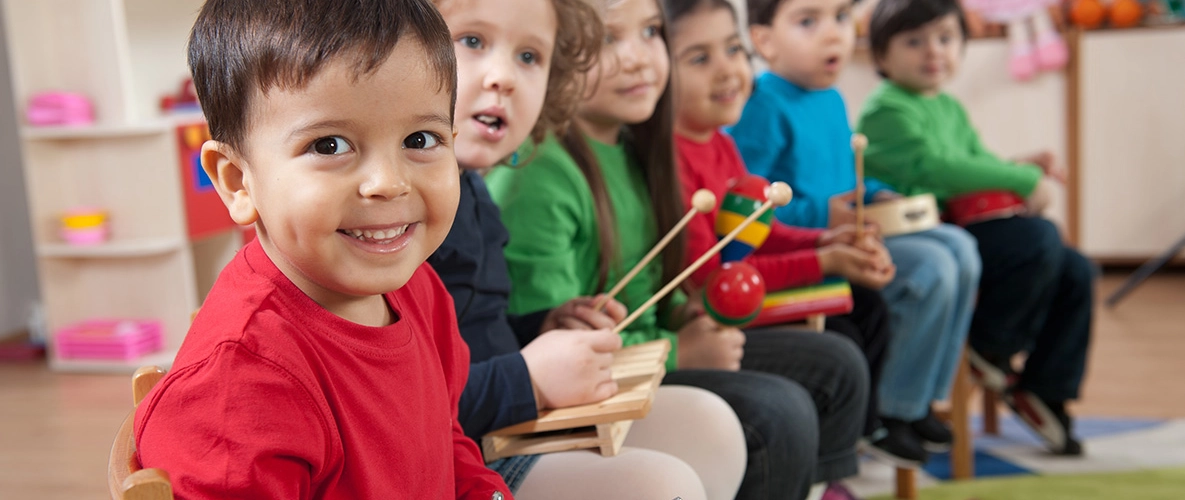 Kinder spielen zusammen auf Instrumenten