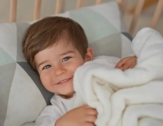 Junge mit Decke im Bett