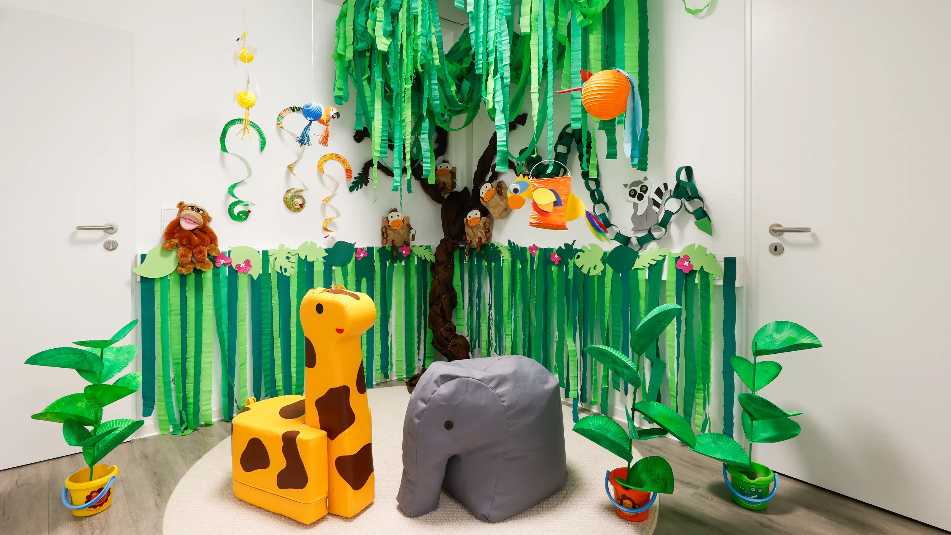 Selbst gebastelte Tiere und Baum aus Kreppband und Spielpapier