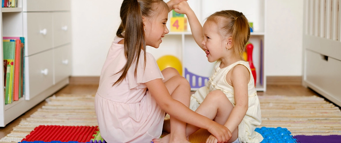 Kinder sitzen auf einem Teppich