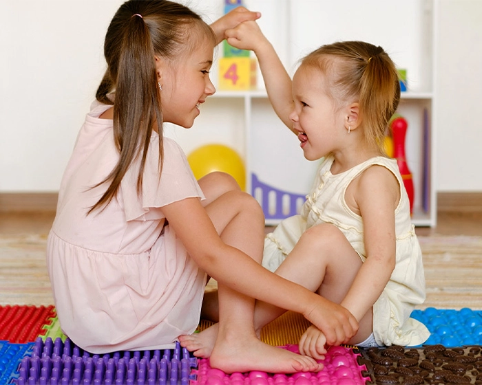 Taktile Wahrnehmung in der Kita Kinder sitzen auf einem Teppich
