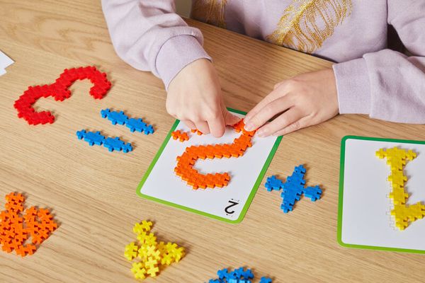 puzzle pieces, colored tiles, letter puzzle, educational game, hand assembling