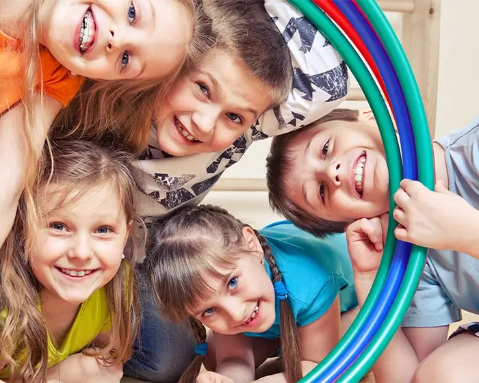 Kooperation in der Kita gestalten und fördern fünf Kinder schauen durch Hoola Hups