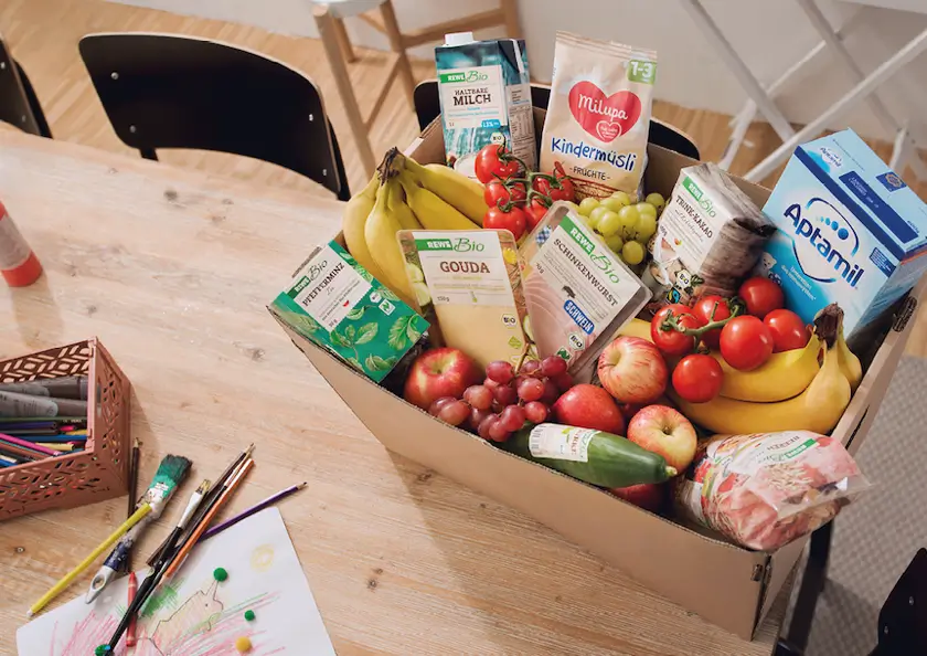 rewe-kiste-mit-lebensmittel-auf-dem-tisch