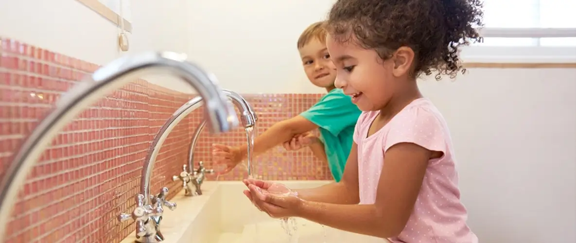 Kinder waschen ihre Hände am Waschbecken