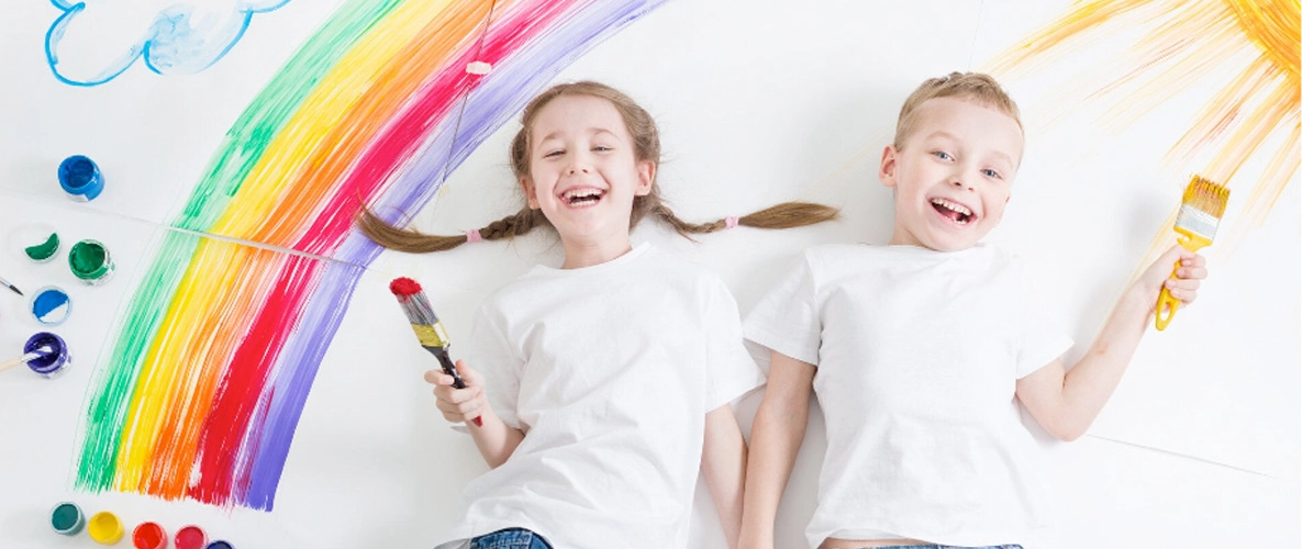 Kinder malen einen Regenbogen mit Pinsel