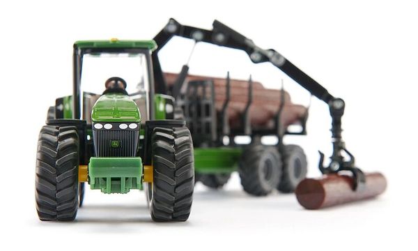 spielzeugtraktor, grüner tractor, lüfterreifen, holzstamm, frontlader