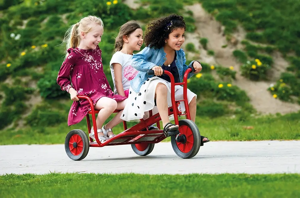 Kinder fahren zusammen Dreirad