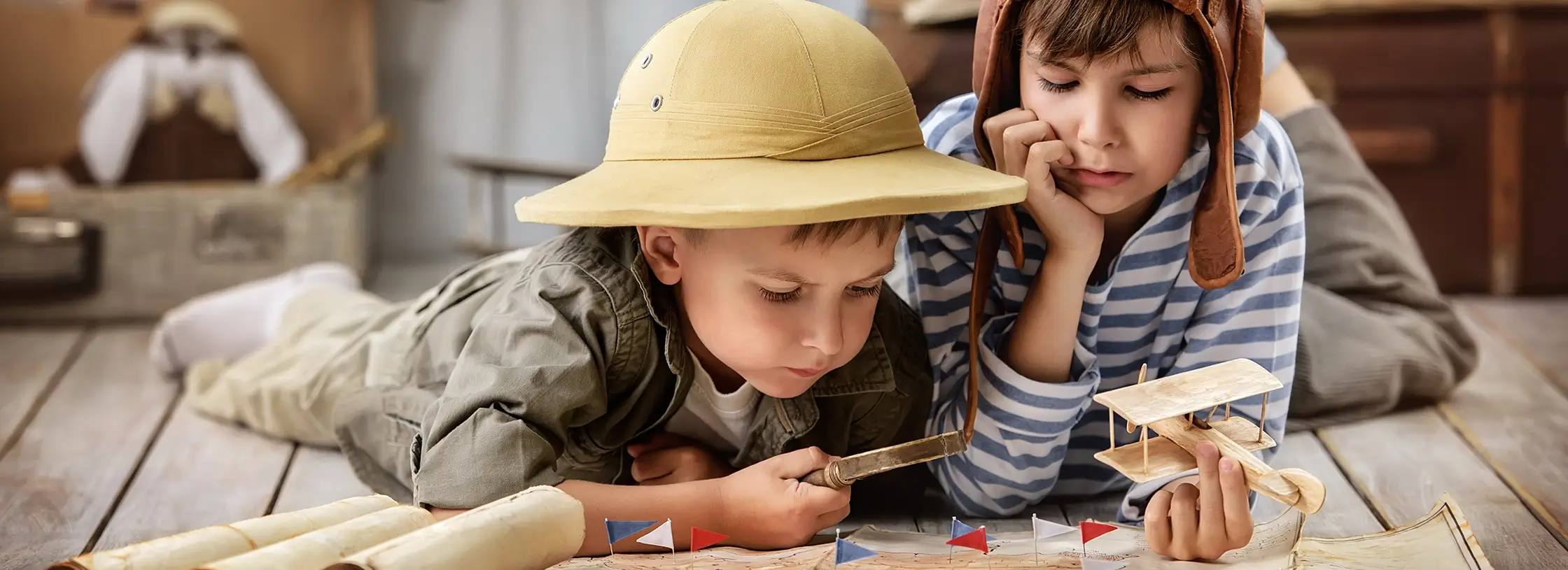 Kita-Projekte: Kinder liegen auf dem Boden verkleidet als Entdecker
