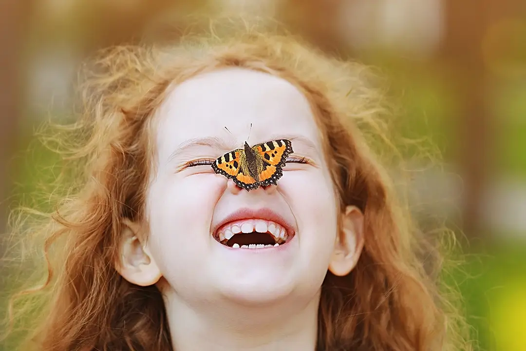 Kita-Projekte zum Thema Schmetterlinge: Mädchen mit Schmetterling auf der Nase