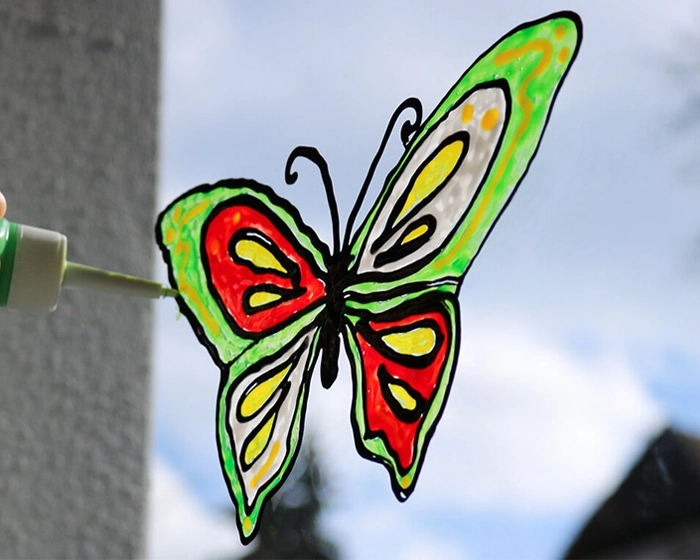 Fenstergestaltung in der Kita Schmetterling ans Fenster mit Windowcolor