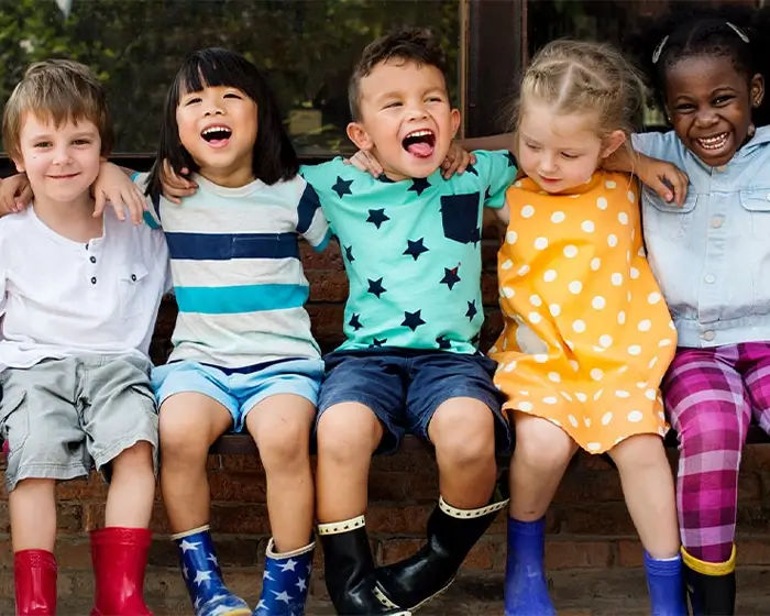 Kulturbewusste Pädagogik in der Kita sechs Kinder sitzen zusammen auf einer Bank