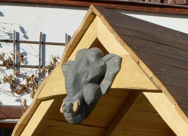 dog head, stone carving, outdoor sculpture, wooden structure, bas-relief
