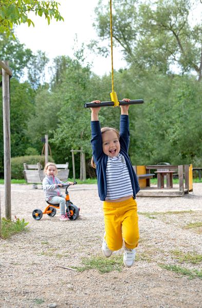 Kinderspielplatz, Hänge-Bar, Hüpfen, Sand/Kies, Kleidung: Gelb