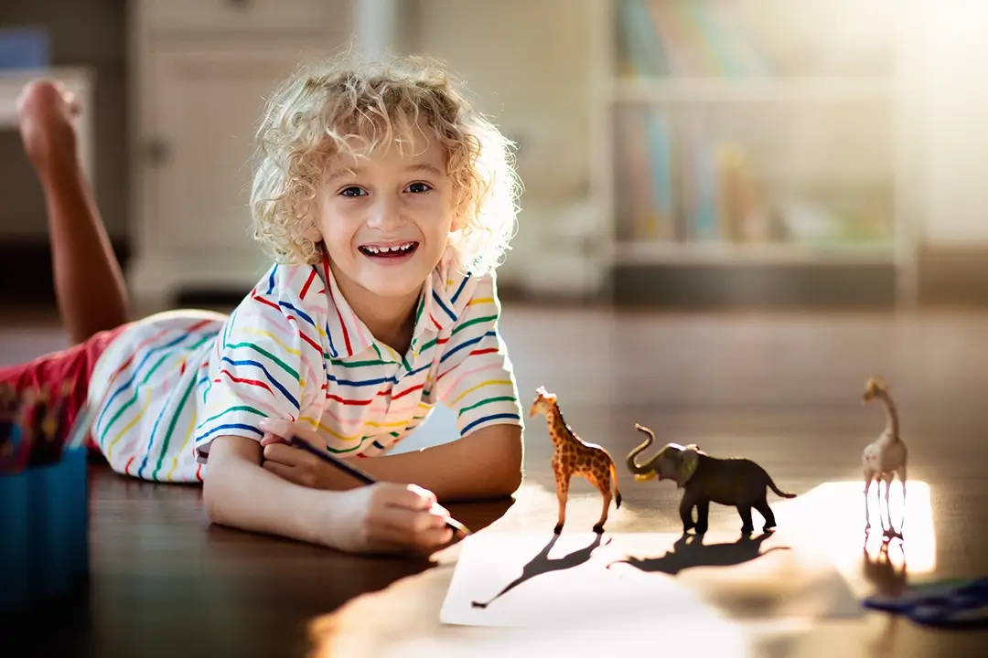Kita-Projekte zum Thema Tiere aus aller Welt: Kind mit Giraffen und Elefanten Figuren